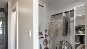 A modern room with a white wardrobe, a round mirror, and a clothing rack with various garments. - Modern 2024 build, in welcoming Lava Hot Springs. Top unit. (Lava Hot Springs)