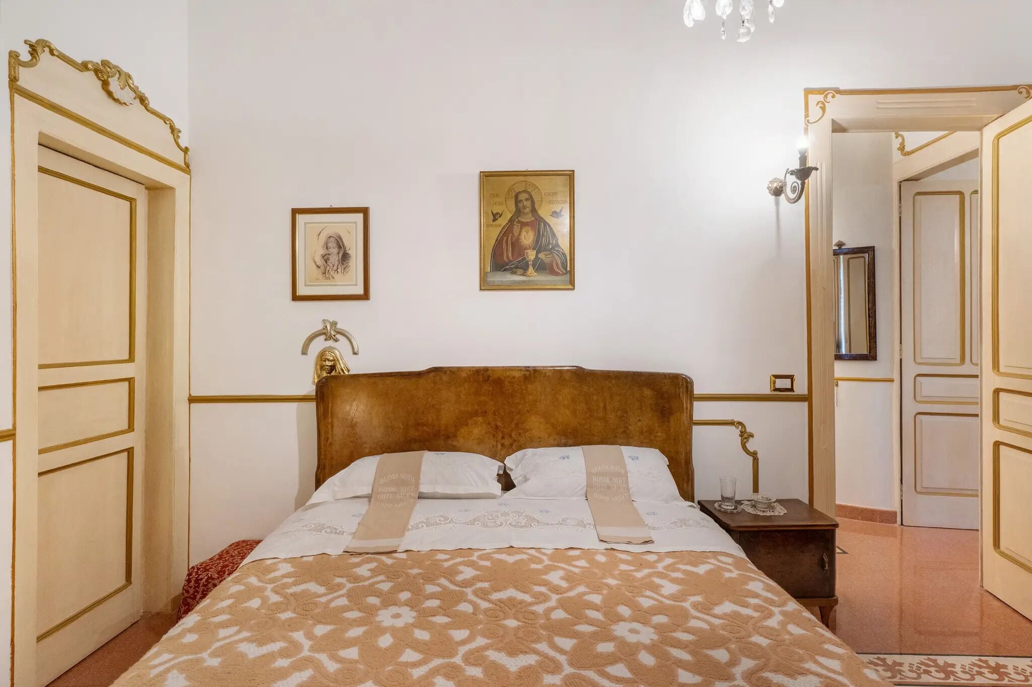 A neatly arranged bedroom with a large bed, a bedside table, and a framed picture on the wall.
