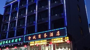 Een hotelgebouw met meerdere verdiepingen en verlichte reclameborden.