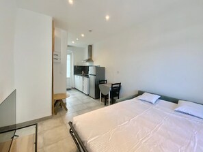 Enjoy a comfortable stay in this stylish room featuring a large bed, desk, and kitchenette.