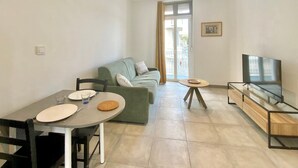 Un salon moderne avec une table à manger, un canapé et un meuble pour la télévision.