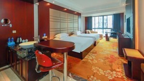 A hotel room with a bed, a desk, a chair, a sink, and a mirror. - Boss Hotel (Huangshan City)