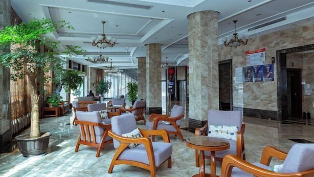 A spacious lobby with marble flooring, wooden chairs, and potted plants. - Boss Hotel (Huangshan City)
