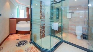 A hotel room with a glass-enclosed shower, a bed, and a bathroom with a toilet and sink. - Boss Hotel (Huangshan City)