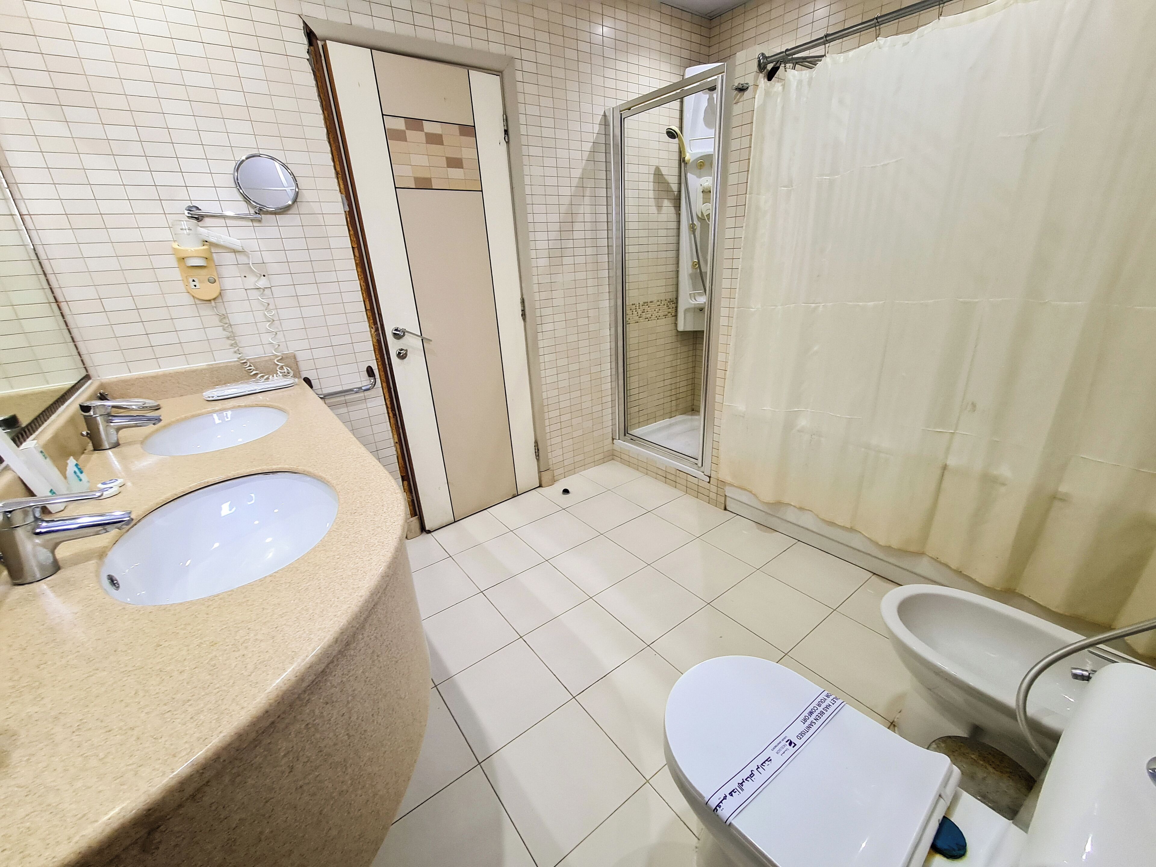 Une salle de bain avec deux lavabos, des toilettes, une douche et un miroir.
