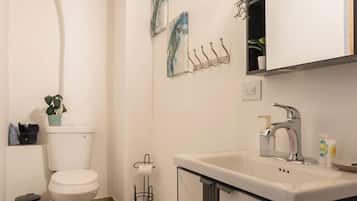 A modern bathroom with a toilet, sink, and mirror.