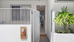 Un edificio residencial con fachada blanca, una puerta visible y el número "307" en la pared.