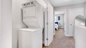 A laundry room with stacked washers and dryers, a carpeted floor, and white walls. - Luxury keyless free WiFi exit 11 (Clarksville)