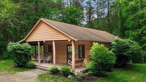 Eine Blockhütte mit Veranda, Essbereich und kleinem Garten.