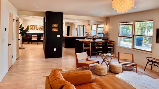 Un salón espacioso con un sofá grande, una cocina con isla central y un comedor con sillas.