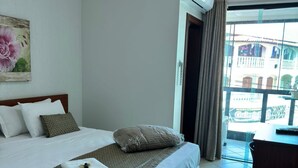 A hotel room with a large bed, a desk, and a view of the outside. - Kaa House Hotel (Carmopolis de Minas)