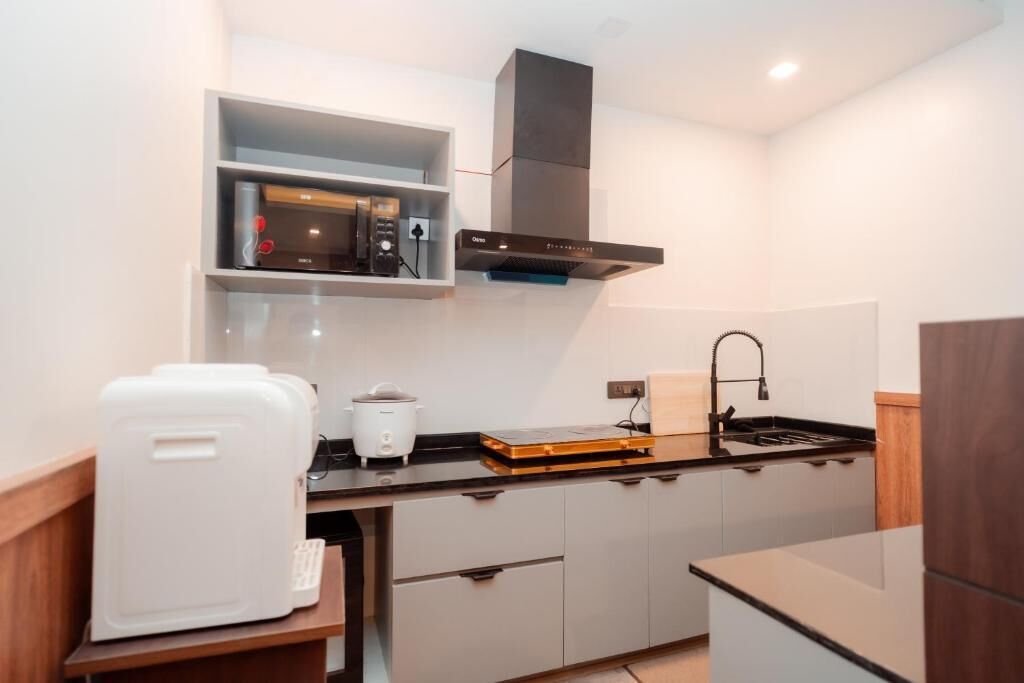 A compact kitchen with a microwave, toaster, and a built-in oven.