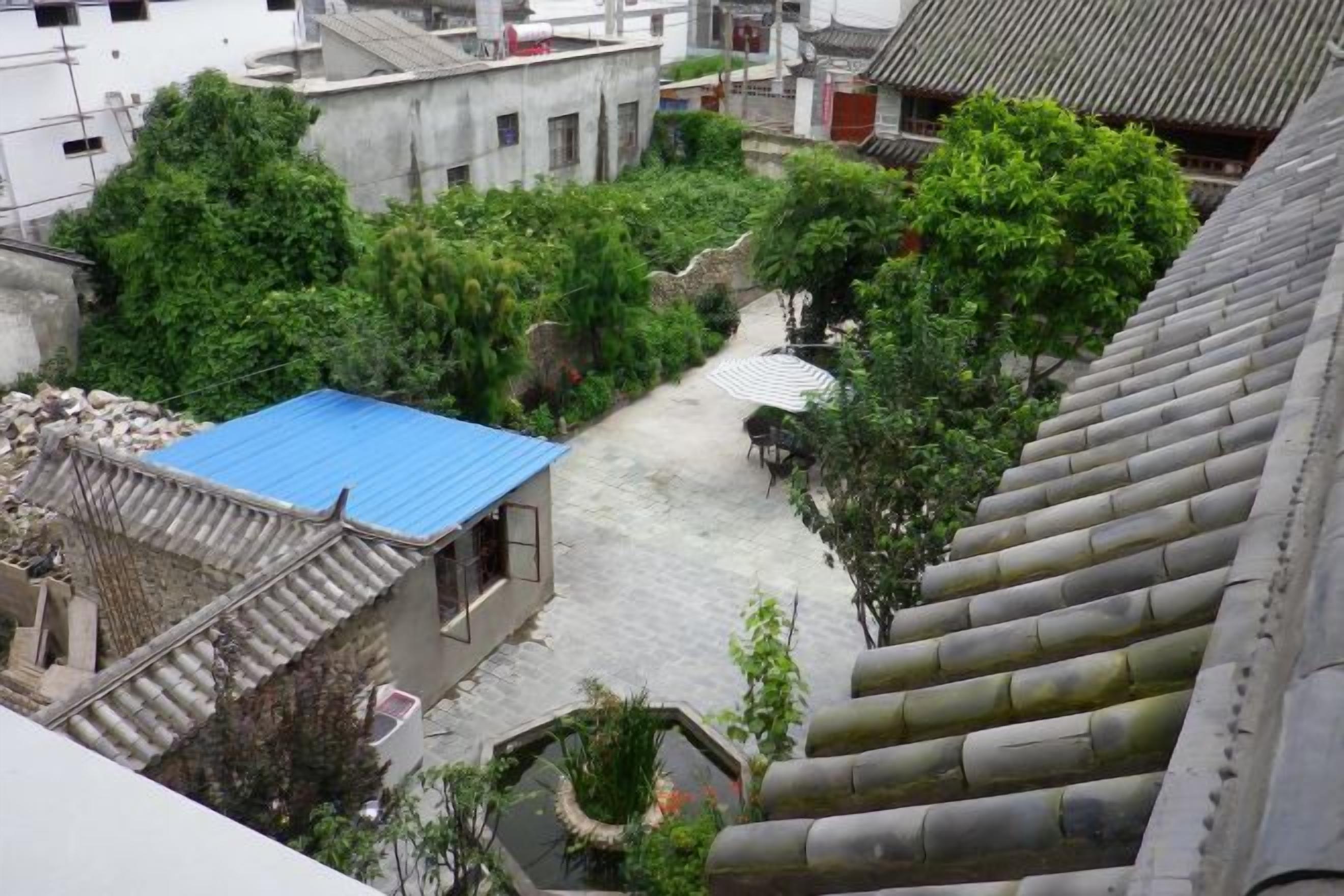 A courtyard with traditional architecture, including a building with a blue roof and a stone staircase.