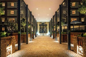 Un pasillo de hotel con paredes de ladrillo, columnas y una entrada central.