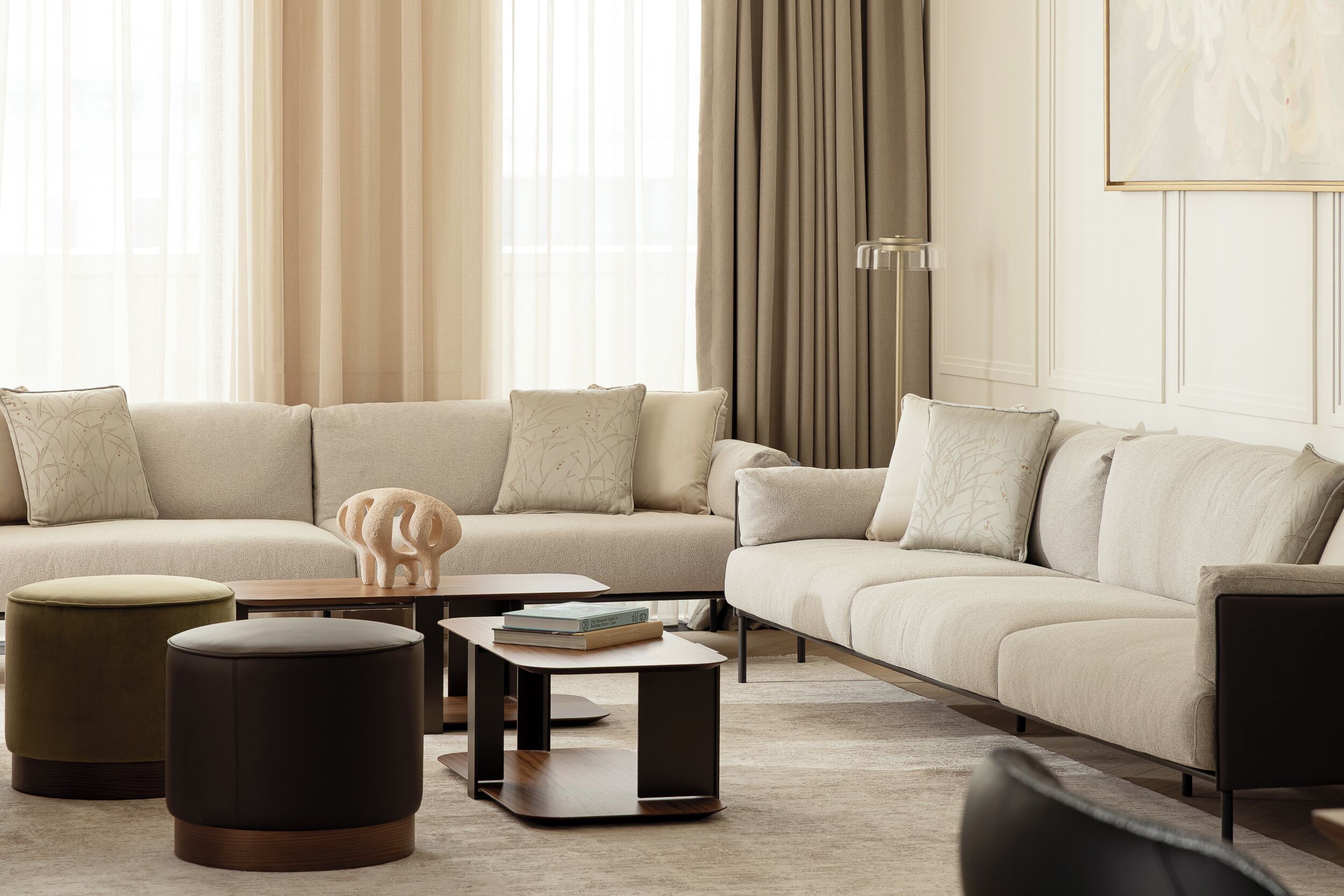 A modern living room with a sectional sofa, ottomans, a coffee table, and a floor lamp.