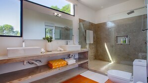 A modern bathroom with a large mirror, two sinks, a shower, and a toilet. - Jungle View Penthouse apt w Pool & Private Rooftop (Sayulita)