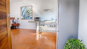 A compact kitchen with a microwave, a small refrigerator, and a shelf with kitchenware. - Jungle View Penthouse apt w Pool & Private Rooftop (Sayulita)