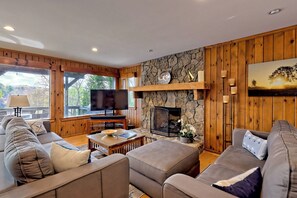 Smart-tv, een open haard, boeken en een computerscherm