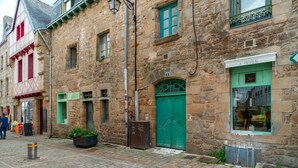 A historic stone building with a green door, a sign reading "PAVILLION," and a small outdoor seating area with a planter. - Le petit Cocon d'Auray - Duplex, proche port St goustan (Auray)