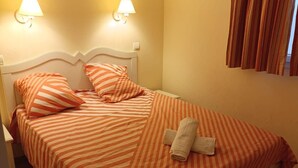 A bed with striped bedding, two wall-mounted lamps, and a window with curtains. - A little cocoon in Provence on the Pont Royal golf course (Mallemort)