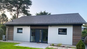 A modern two-story house with a flat roof, large glass doors, and a small front garden. - Renovated vacation home in a quiet location on the outskirts of Berlin (Falkensee)