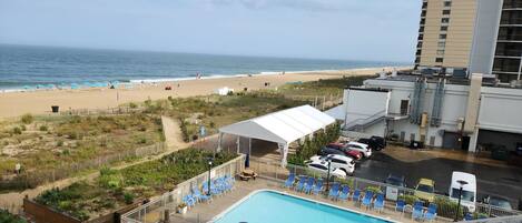 A pool area with a view of the beach and ocean.