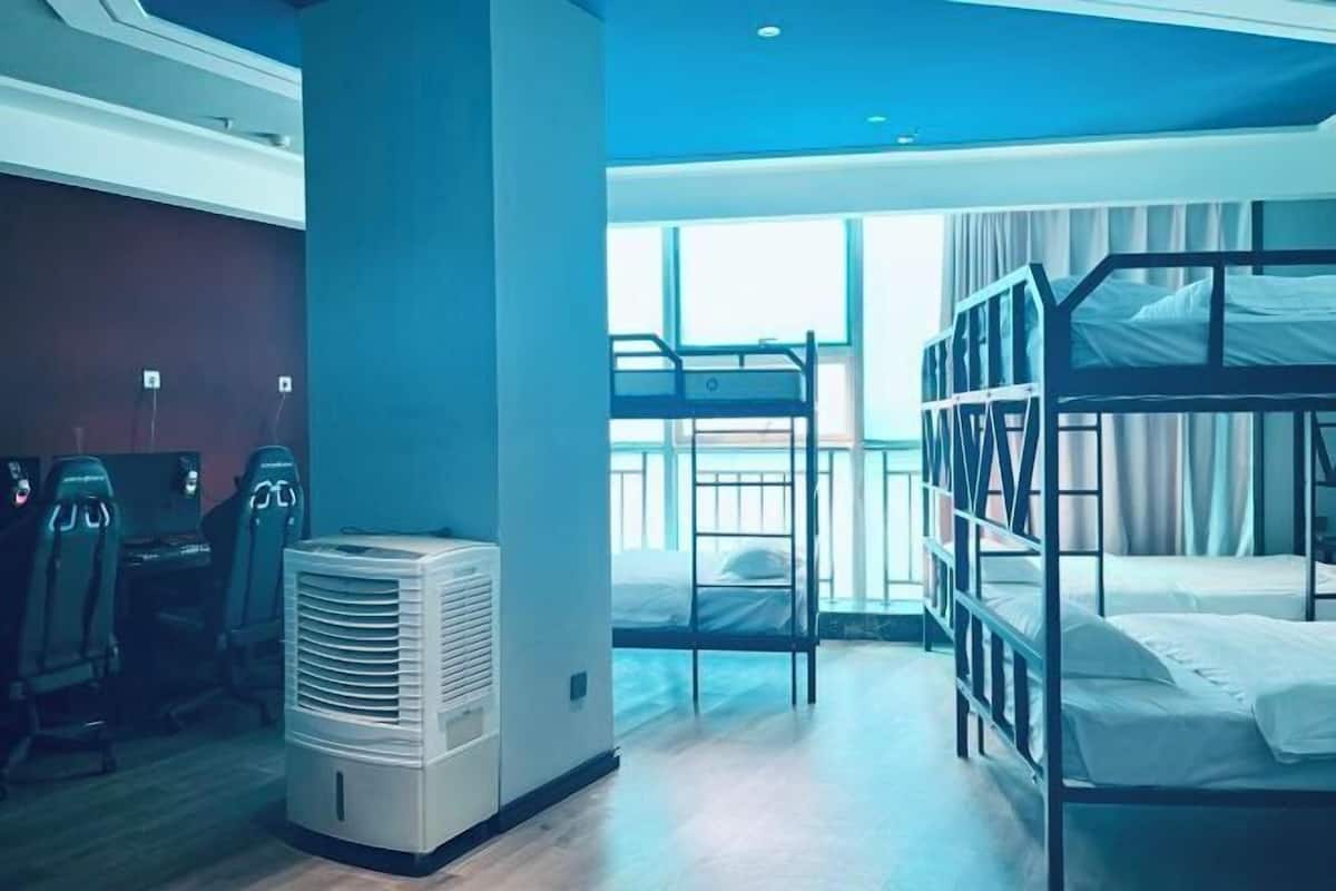 Een kamer met stapelbedden, een elektrische kachel en een raam met gordijnen.