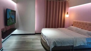 A bedroom with a bed, a television, and a curtain. - Urumqi Sundan Yakaifu Theme Hotel (Urumqi)