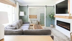 A modern living room with a sofa, coffee table, and fireplace. - Charleston House with Private Pickleball Court! (Charleston)