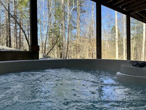 A hot tub with a view of a forest through large windows. - Beautiful 4 bedroom in Red River Gorge with wi-fi and hot tub (Stanton)