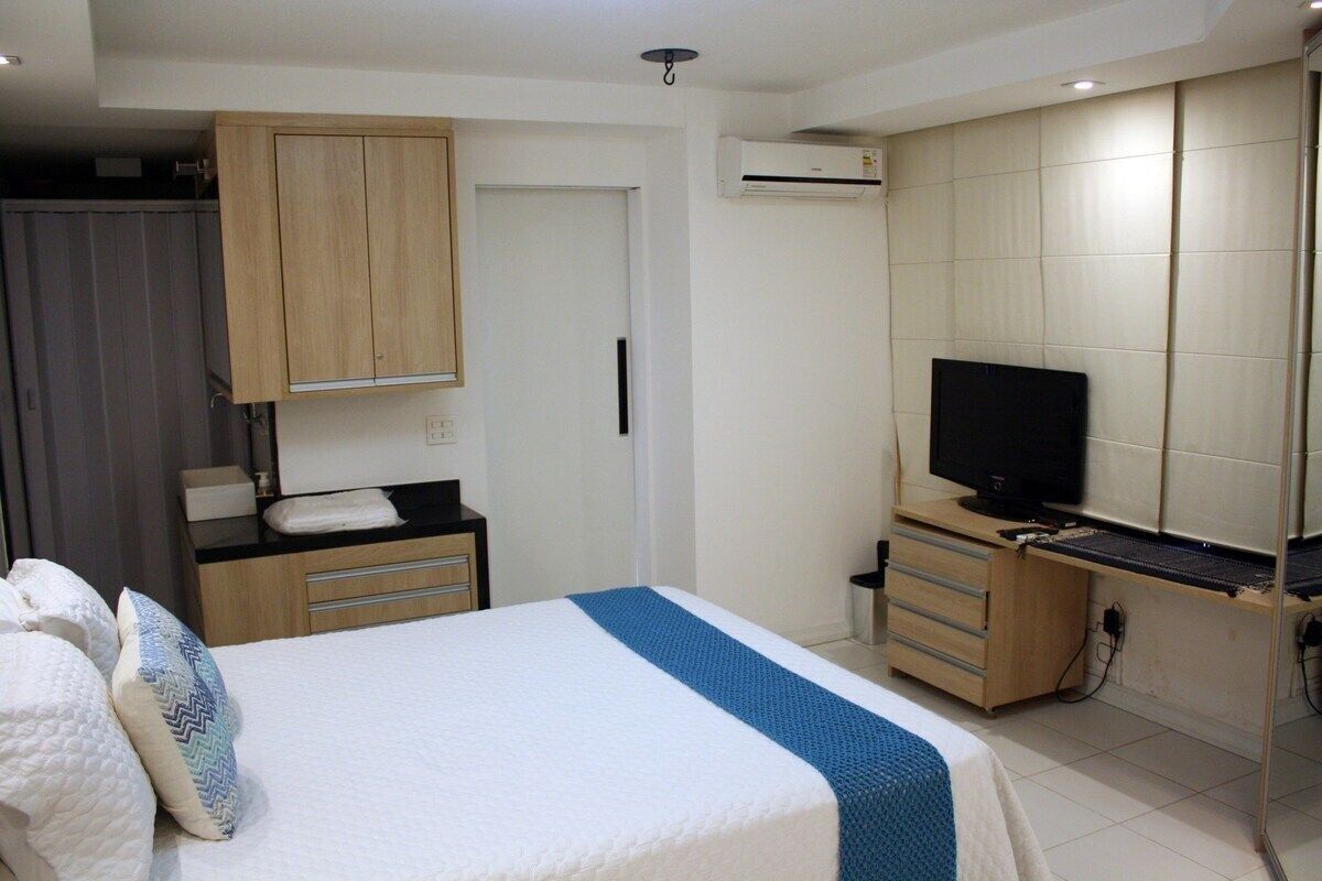 Une chambre à coucher comprenant un lit, une télévision, une armoire et un bureau.
