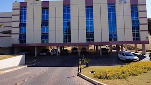Un edificio moderno con una zona de estacionamiento al frente.