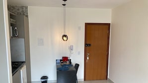 Una cocina compacta con refrigerador, estufa y comedor con mesa y sillas.