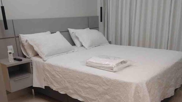 Une chambre d’hôtel équipée d’un lit, d’une table de chevet, d’une chaise et d’un appareil de climatisation.