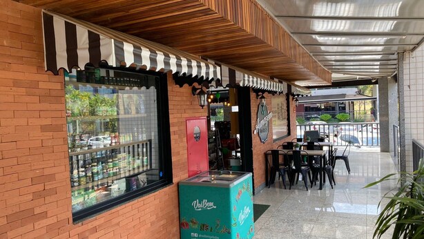 A cafe with a brick facade, wooden ceiling, and outdoor seating area. - Loft 34m² Asa Norte CLN 213 (Brasília)