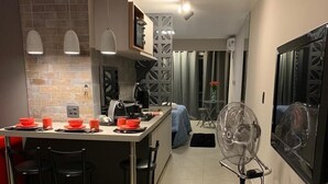 Eine moderne Küche mit einer zentralen Kochinsel, Barhocker und einem Esstisch, gedeckt mit roten Schüsseln.