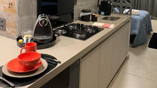 Eine moderne Küche mit Einbauofen, Kaffeemaschine und Gasherd.