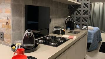 Cozinha moderna com forno embutido, cafeteira e fogão a gás.