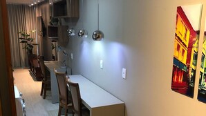 Une cuisine moderne dotée d’un grand îlot central, de luminaires suspendus et d’un coin repas avec des chaises.