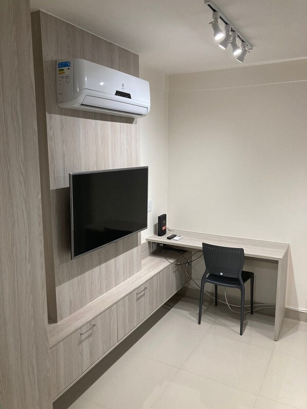 Una cocina moderna con estufa integrada, microondas y un televisor de pantalla plana grande montado en la pared.