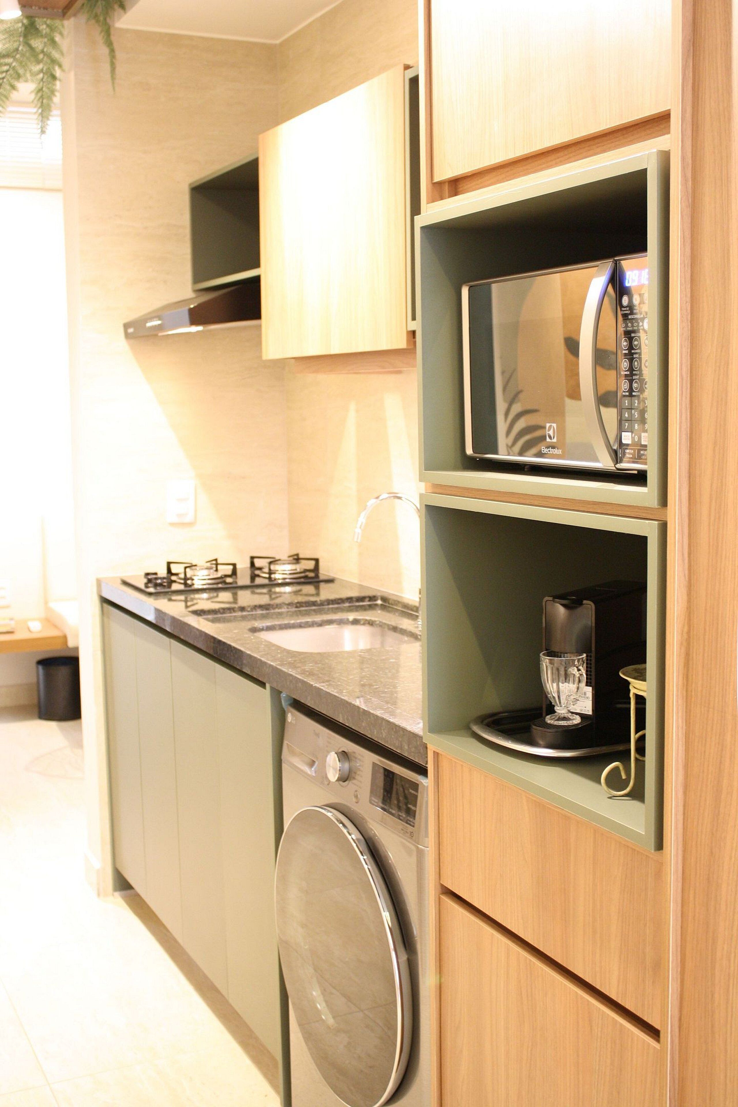 Una cocina compacta equipada con microondas, lavavajillas y pileta.