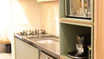 Una cocina compacta equipada con microondas, lavavajillas y pileta.