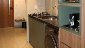 Et moderne køkken med indbyggede hårde hvidevarer, vaskemaskine og mikroovn.