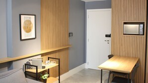 Une pièce moderne avec un mur d’accent en bois, une porte blanche, une petite table avec une chaise et un tableau encadré accroché au mur.