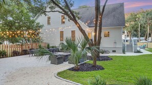 A house with a patio, outdoor furniture, and string lights.