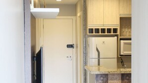 A modern kitchen with a built-in microwave, a refrigerator, and a small island with a sink.