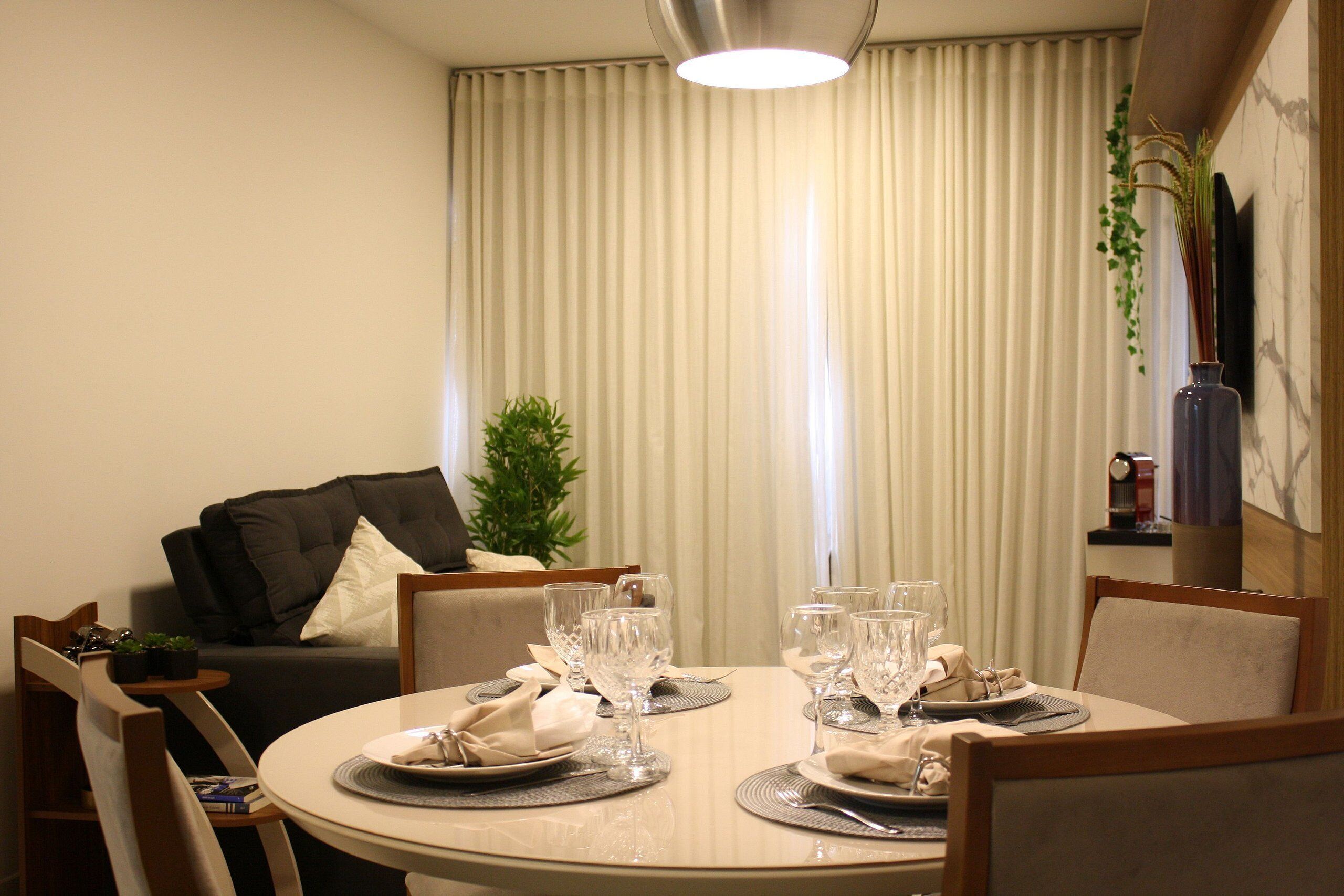 Comedor con mesa redonda dispuesta para cuatro personas, rodeada de sillas.