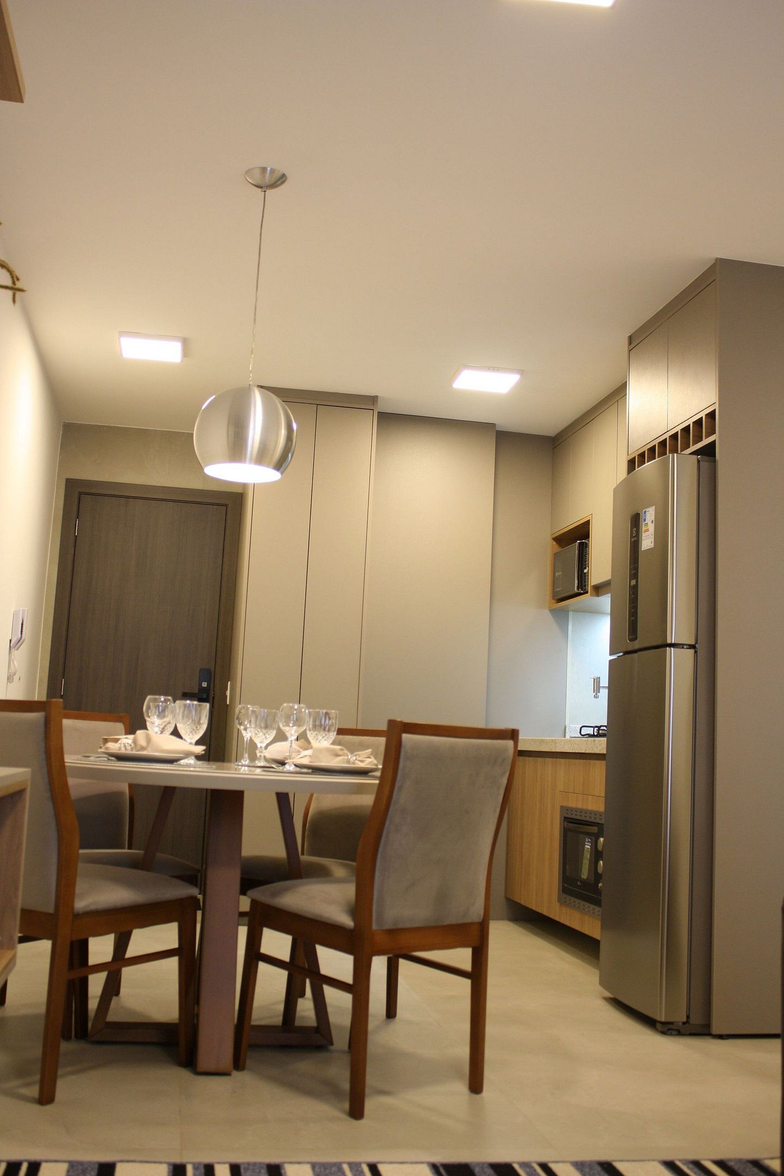 Una cocina moderna con comedor, electrodomésticos de acero inoxidable y sillas de madera.