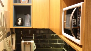 A compact kitchen with a toaster, a microwave, and a sink.