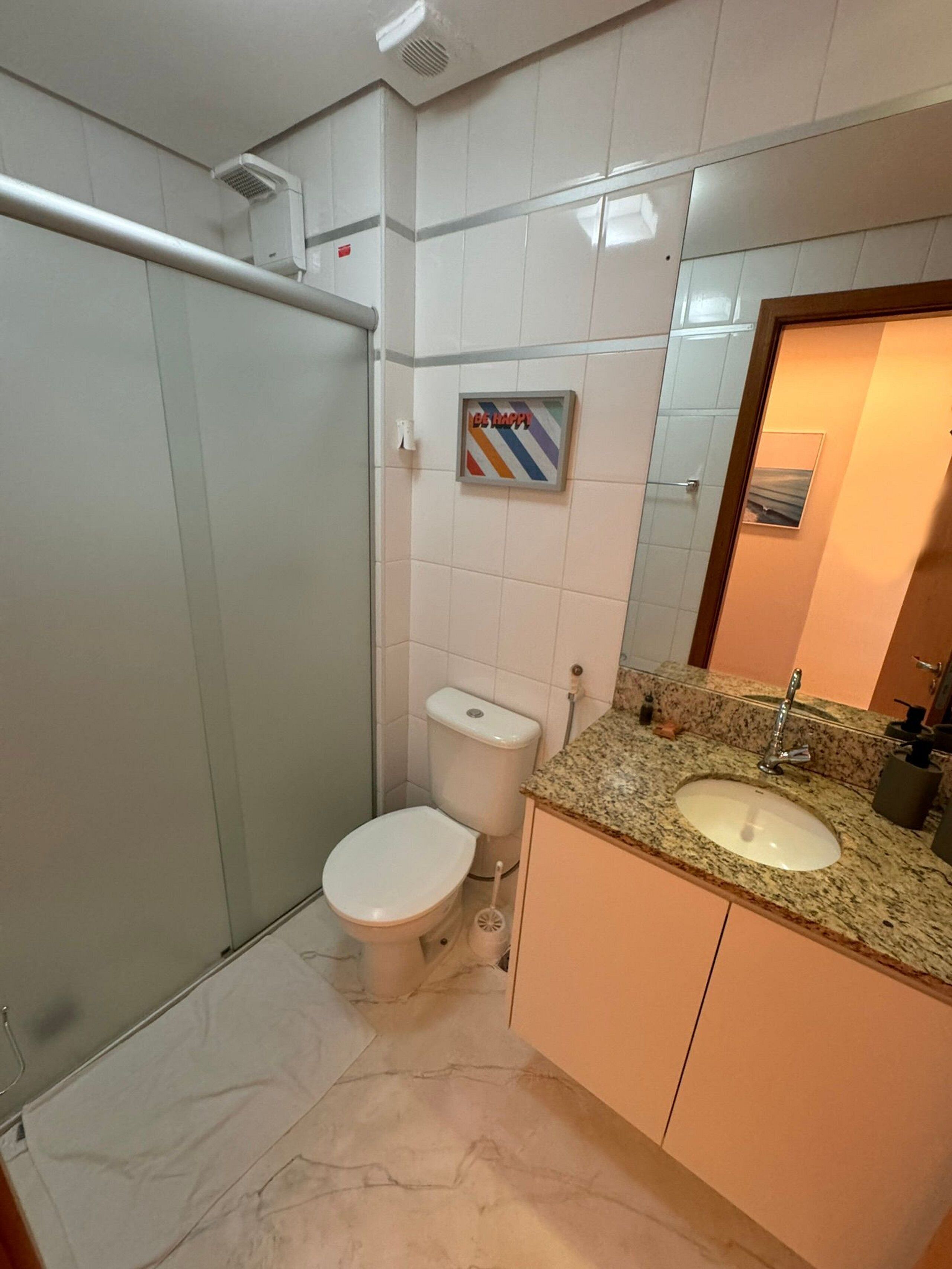 A bathroom with a toilet, sink, and shower.